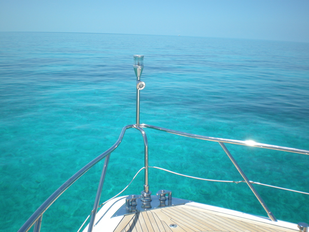 Bow of a yacht over clear turquoise water
